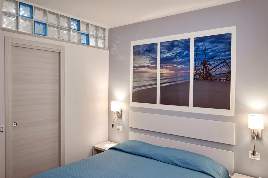 Camera da letto con letto blu e due finestre a Best Vasto