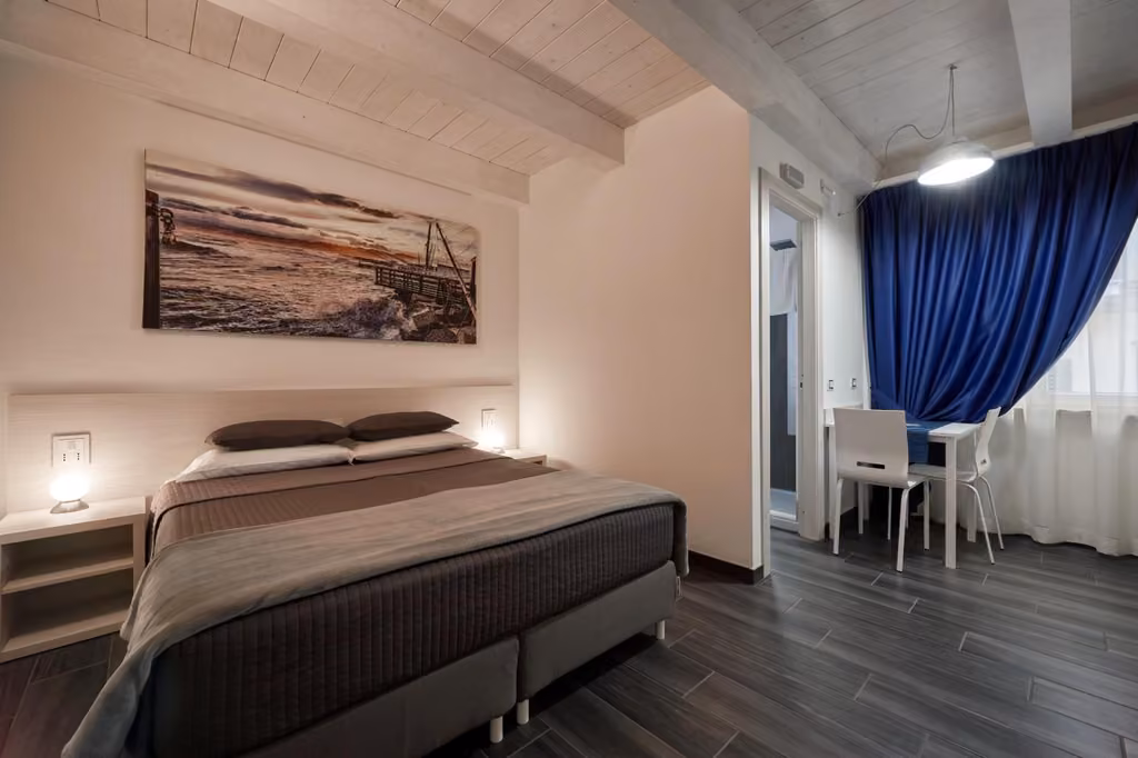 Camera con letto, scrivania e tavolo